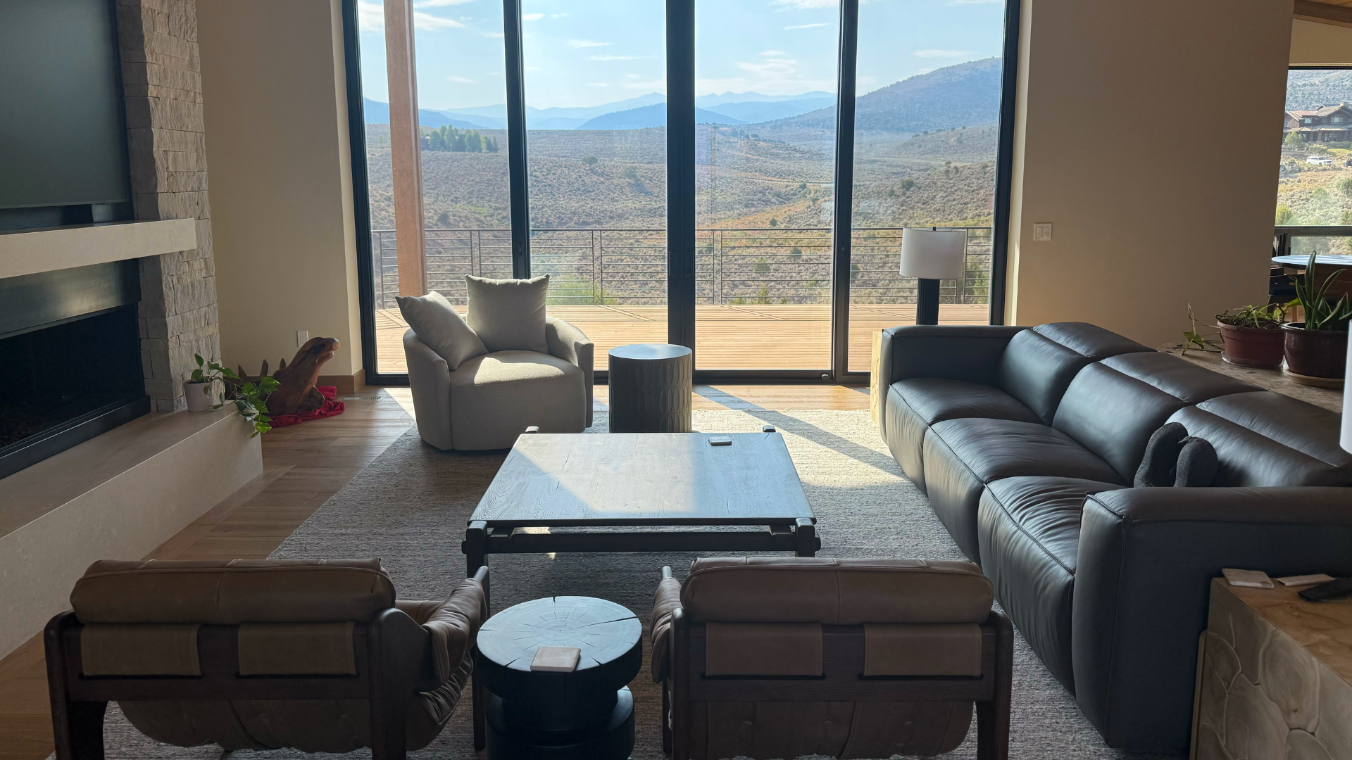 floor to ceiling windows in living room with area rug and custom tile surround fireplace in Avon, CO home