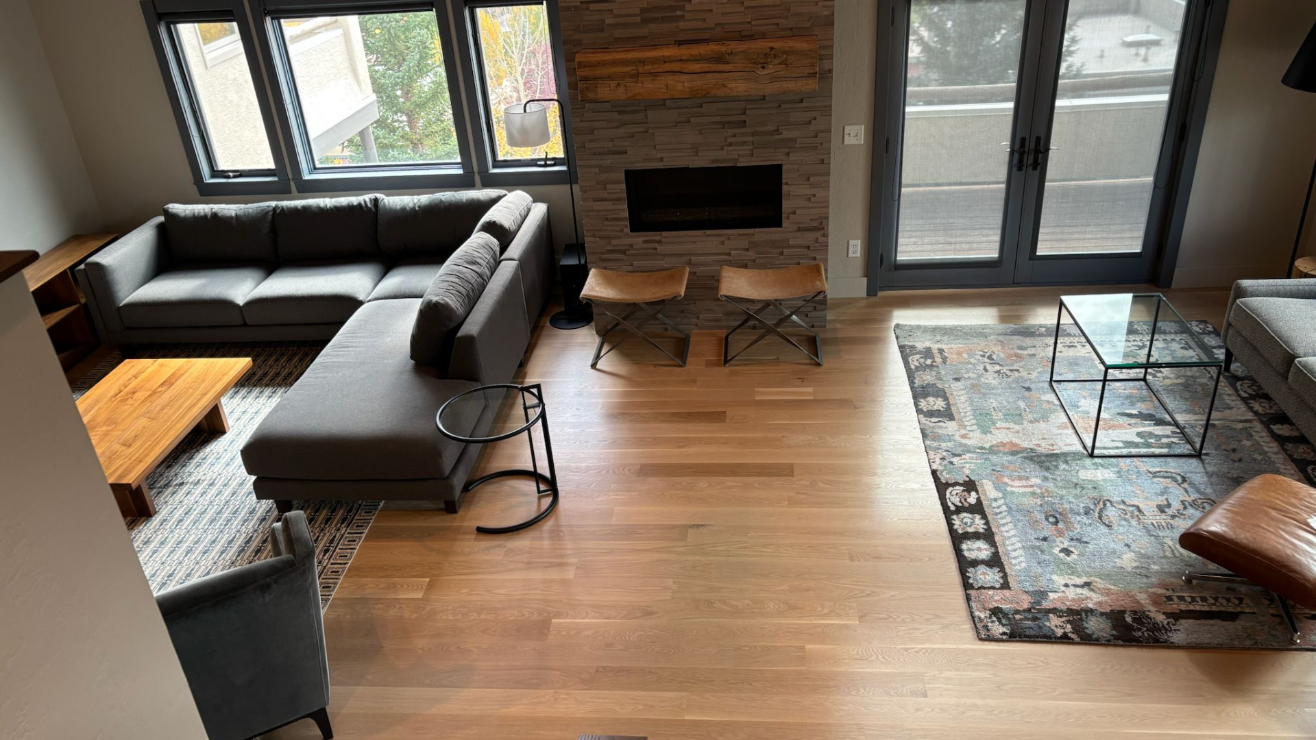 Modern living room with luxury hardwood flooring and oversized windows